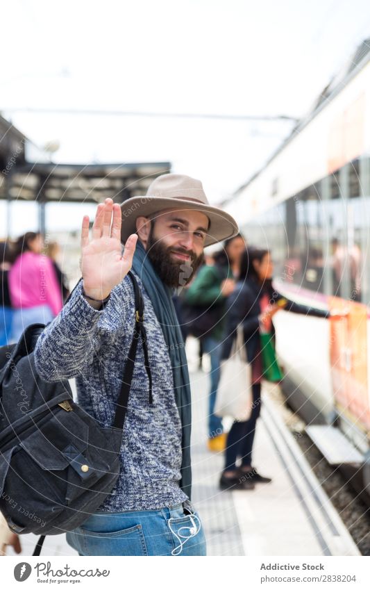 Fröhlicher Tourist am Bahnhof Mann Eisenbahn Station Begrüßung gestikulieren Abschied Blick in die Kamera Ferien & Urlaub & Reisen Verkehr Ausflug Rucksack