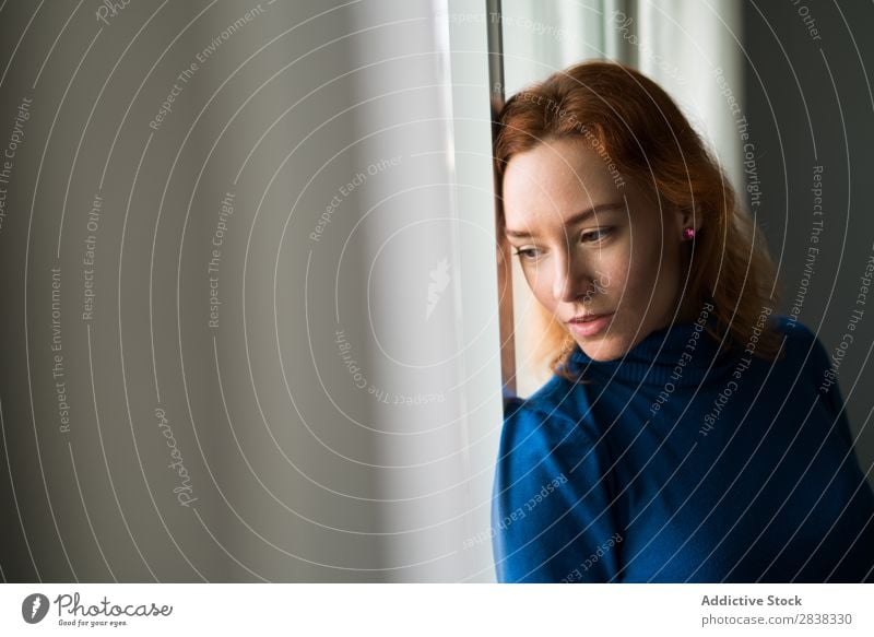 Nachdenkliche Frau am Fenster hübsch Fürsorge stehen schön rothaarig Jugendliche attraktiv Mensch Mädchen Porträt Denken besinnlich Dame Beautyfotografie lässig