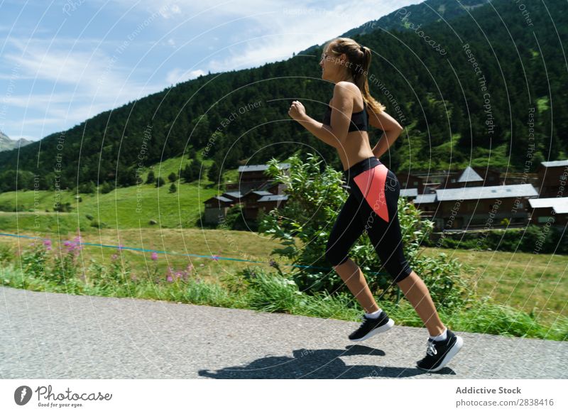 Frau beim Joggen auf dem Land Straße ländlich sportlich Jugendliche Fitness üben Athlet Sport Landschaft Training Freizeit & Hobby Aktion Sportbekleidung Gras