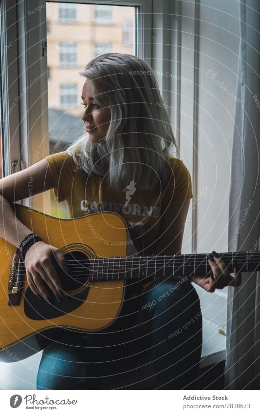 Musikant am Fenster sitzend Frau hübsch heimwärts Jugendliche Musiker Gitarre Inspiration Spielen blond schön Lifestyle Beautyfotografie attraktiv Porträt Dame