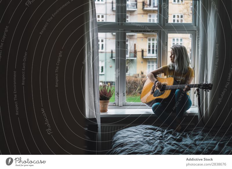 Musikant am Fenster sitzend Frau hübsch heimwärts Jugendliche Musiker Gitarre Inspiration Spielen blond schön Lifestyle Beautyfotografie attraktiv Porträt Dame