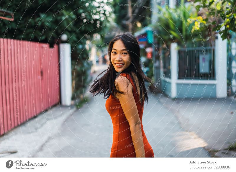 Fröhliche Frau, die auf der Straße posiert. hübsch asiatisch Jugendliche heiter Glück Freude grün Stadt schön Porträt attraktiv Beautyfotografie Mensch niedlich