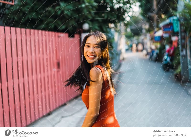 Fröhliche Frau, die auf der Straße posiert. hübsch asiatisch Jugendliche heiter Glück Freude grün Stadt schön Porträt attraktiv Beautyfotografie Mensch niedlich