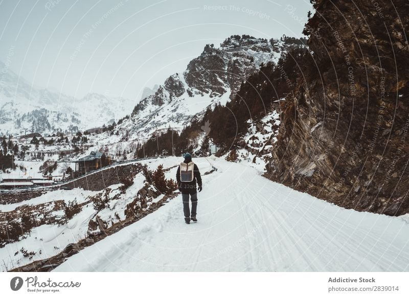 Mann, der auf einer verschneiten Straße geht. Winter Hügel Berge u. Gebirge Schnee Landschaft Natur weiß Eis Jahreszeiten kalt Ferien & Urlaub & Reisen Weg Wald