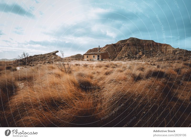 Kleines Haus und Hügel Berge u. Gebirge Natur regenarm Gebäude Landschaft Ferien & Urlaub & Reisen Wüste Landen Gras Sand Boden Umwelt gelb Stein Wildnis schön