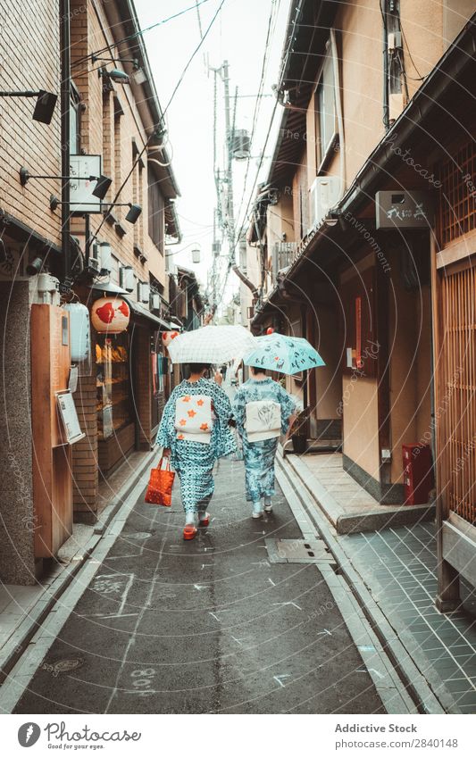 Frauen in asiatischer traditioneller Kleidung Tradition Bekleidung Regenschirm laufen Zusammensein Haus Holz heimwärts Asien Japaner Architektur altehrwürdig