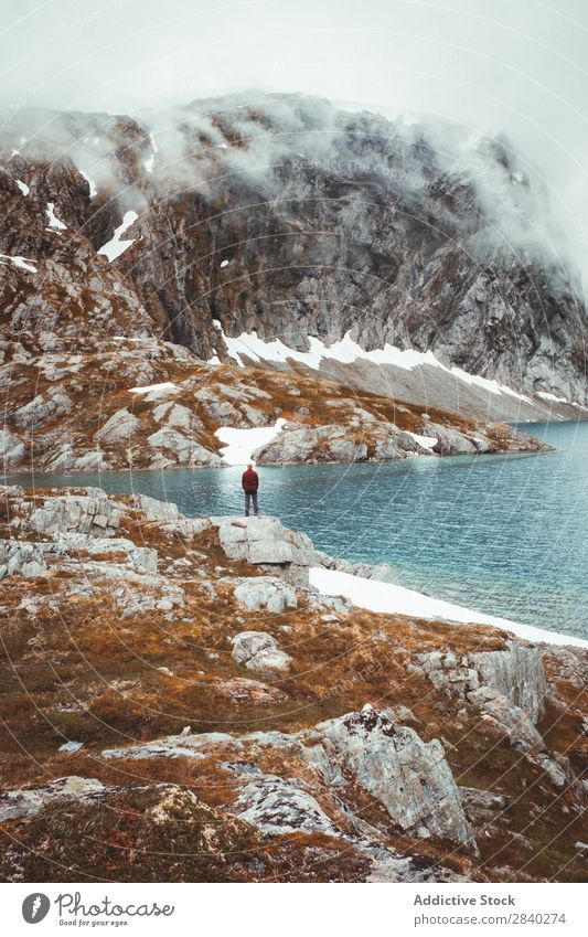 Person am felsigen Ufer in den Bergen Mensch See Berge u. Gebirge Reisender Tourismus Schnee Reflexion & Spiegelung geheimnisvoll Landschaft Felsen