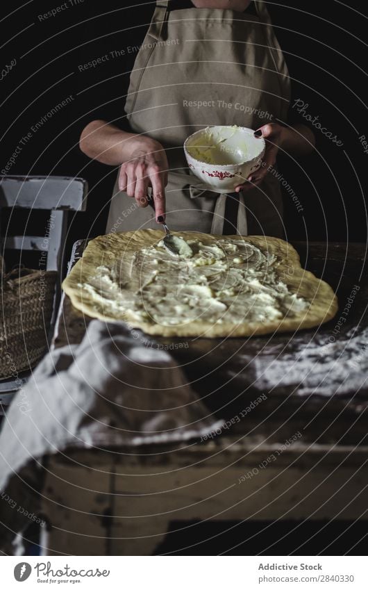 Frau, die die Füllung auf den Teig legt. Mensch kochen & garen Teigwaren kneten rustikal Mehl Lebensmittel Schalen & Schüsseln Putten Küchenchef Bäckerei