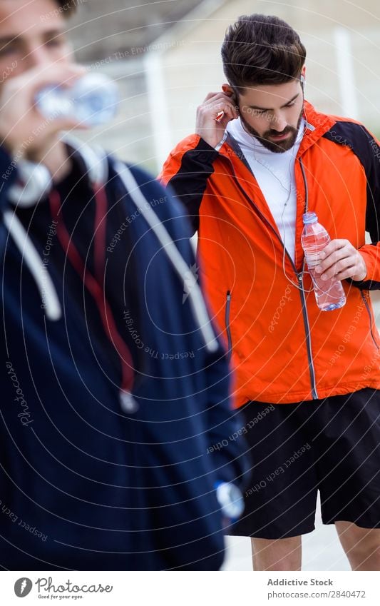 Zwei junge Männer ruhen sich aus, nachdem sie auf der Straße gelaufen sind. Aktion Erwachsene Athlet attraktiv Wesen Körper Fürsorge Kaukasier üben sportlich