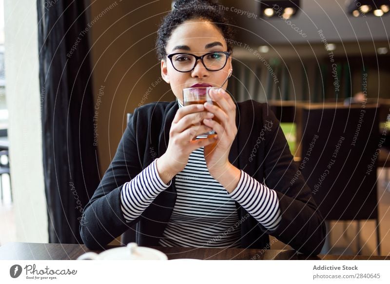 Schöne junge Frau, die Tee im Kaffee trinkt. trinken im Innenbereich Café Tisch attraktiv sitzen Getränk Vesper Pause Erwachsene Tasse Frühstück genießen