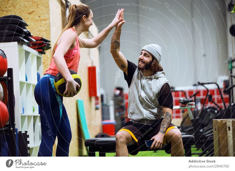 Sportliche Menschen, die sich im Fitnessstudio anfeuern. Sporthalle Training sportlich üben Lifestyle high five Applaus Gesundheit Sportbekleidung Aktion schön