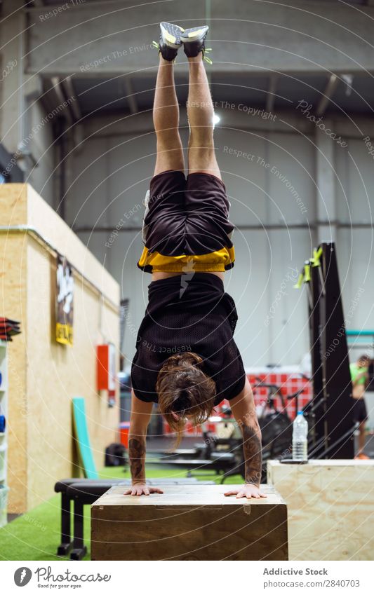 Mann steht kopfüber im Fitnessstudio. Sporthalle Training sportlich üben Lifestyle auf den Kopf gestellt auf Händen stehen Gesundheit Sportbekleidung Aktion