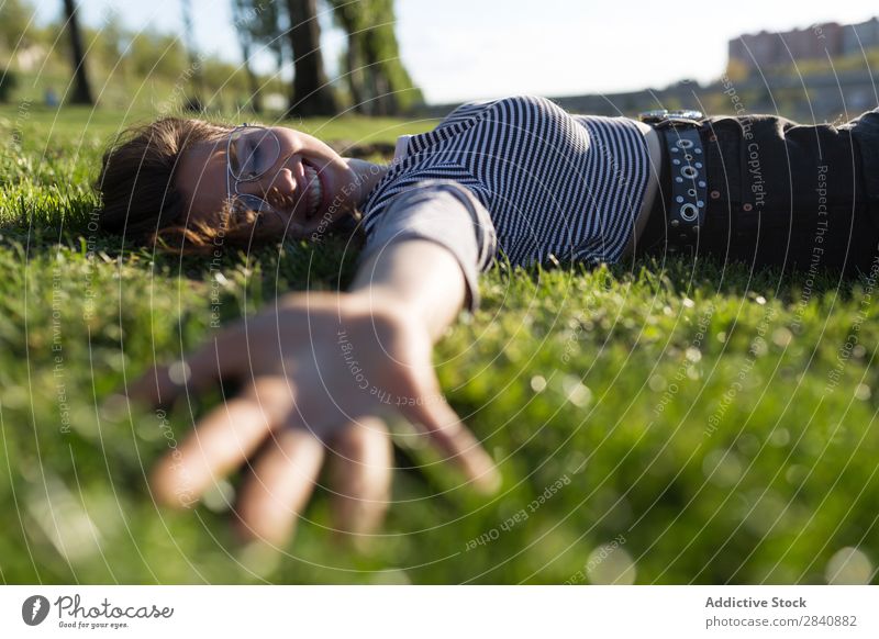 Lachende Frau auf Gras liegend mir folgen Park Natur Sommer träumen Ferien & Urlaub & Reisen romantisch Abenteuer Lächeln Fröhlichkeit Stil Jugendliche grün