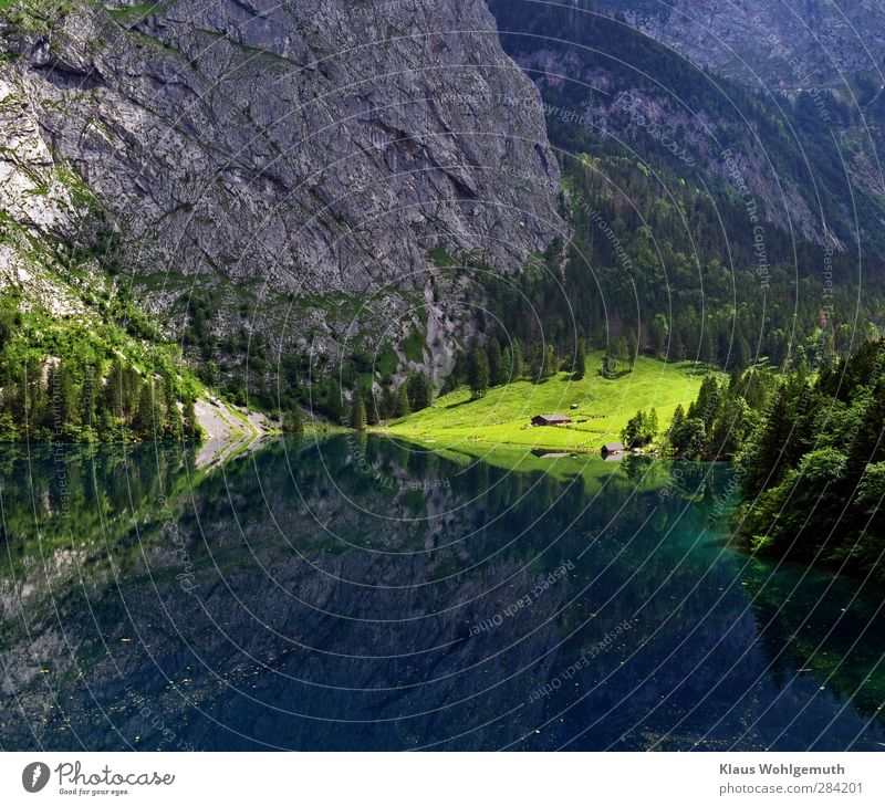 Fischunkelalm hinter dem Obersee wird von einem Sonnenstrahl erhellt. Berge, Wiesen und Bäume spiegeln sich im Wasser. Erholung ruhig Meditation Tourismus