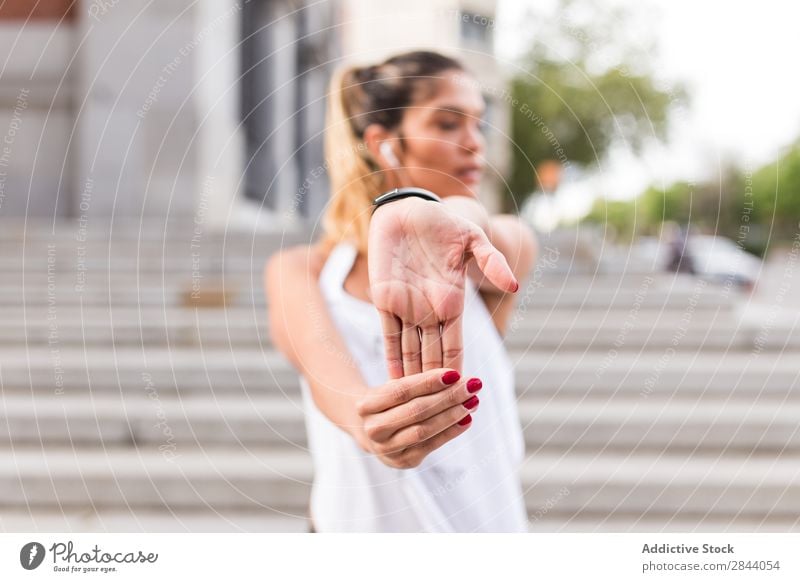 Sportliche Frau beim Aufwärmen auf der Straße Stadt Training strecken Sportbekleidung Gesundheit Aktion Dehnübung üben Großstadt Morgen sportlich Fitness Körper