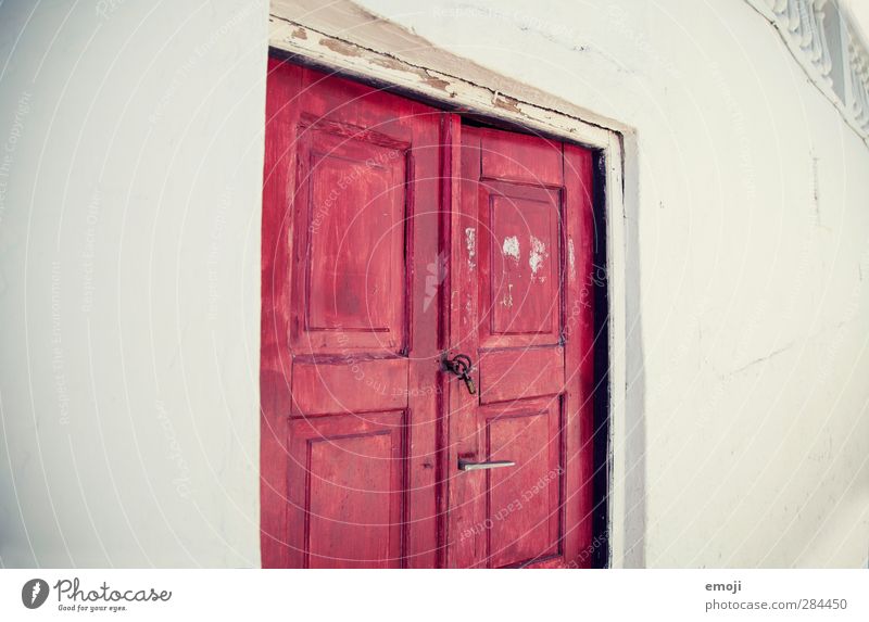 the red door Dorf Haus Einfamilienhaus Mauer Wand Fassade Tür rot weiß Tor Farbfoto Außenaufnahme Textfreiraum links Textfreiraum rechts Hintergrund neutral Tag