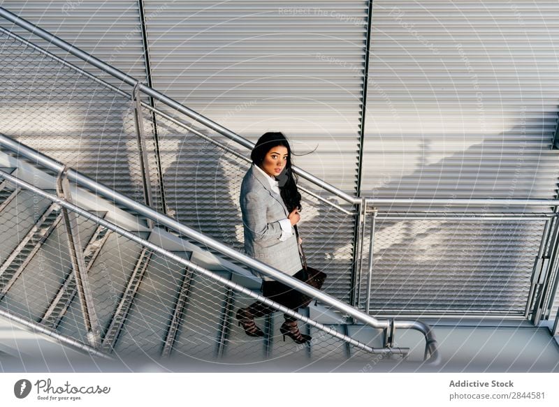 Elegante Frau, die auf der Straße die Treppe hinuntergeht. Stil laufen schön Jugendliche hübsch Lifestyle selbstbewußt Geschäftsfrau attraktiv elegant Glück