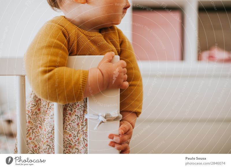 Kind steht in einer Krippe. Lifestyle einrichten Babybett Mensch feminin Kleinkind Mädchen 1 1-3 Jahre beobachten hören liegen stehen authentisch einfach