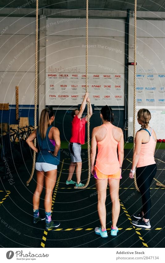 Frauen beobachten Sportler Kletterseil Ausbilderin Seil Klettern Sporthalle üben Ausdauer Aktion Training muskulös Kraft Konzentration ausarbeitend Team