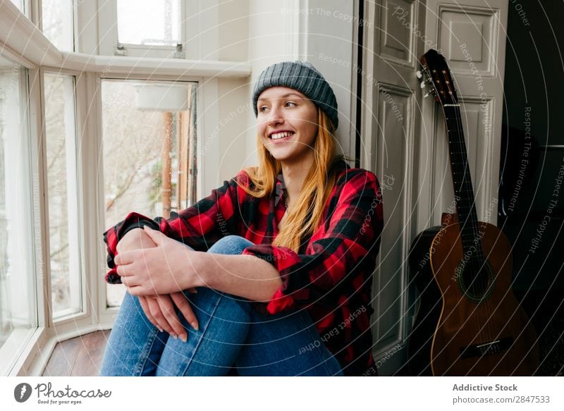 Fröhliche blonde Frau, die am Fenster posiert. heimwärts Jugendliche schön heiter Lächeln Hut hübsch Beautyfotografie Glück Mensch Raum niedlich genießen