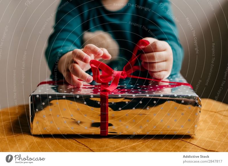 Schneiden Sie Kinder, die das Band an der Box binden. Geschenk Weihnachten & Advent Ferien & Urlaub & Reisen Kopplungsbindung Hand Schnur Kasten Glück