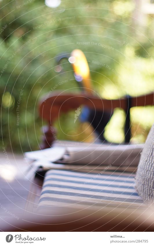 Gartenbank mit Zeitung Häusliches Leben Zeitschrift Schönes Wetter Regenschirm Sitzpolster Geborgenheit Erholung Freizeit & Hobby Morgenzeitung Stuhllehne