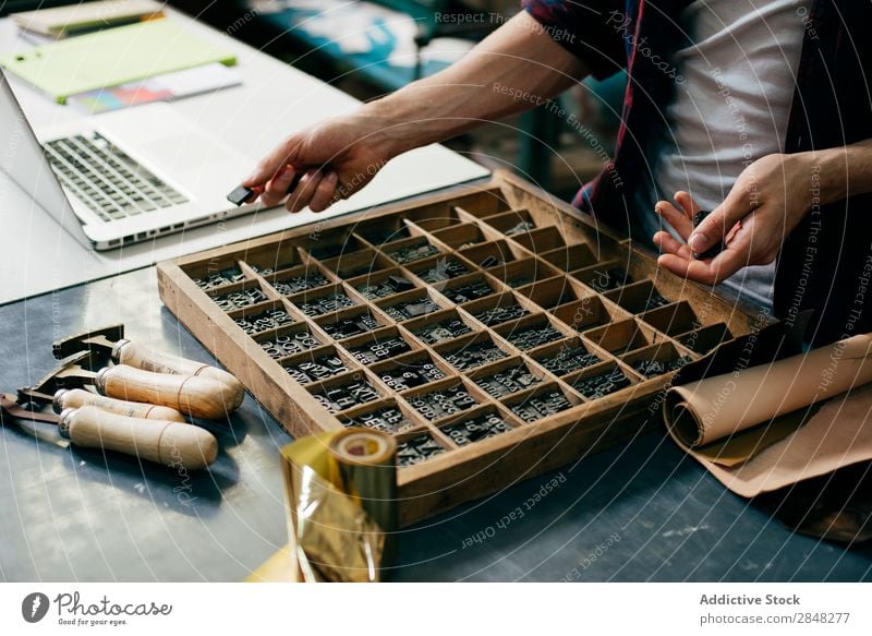 Zuschneider beim Auswählen von Druckbuchstaben Kunsthandwerker Typographie Brief auserwählend Stempel Arbeitsplatz Sammlung Tradition Arbeitsbereich Ausdruck