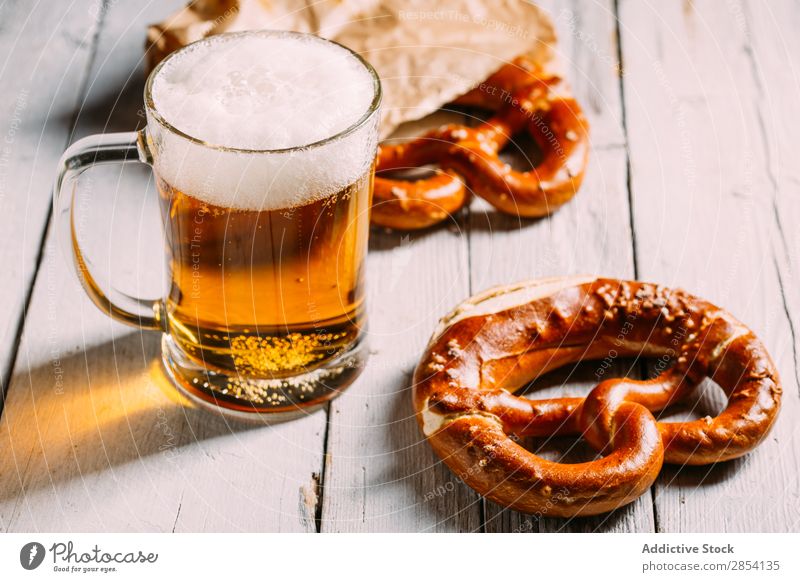 Bierglas und Brezel Bar Getränk Coolness trinken Schaum Lebensmittel Glas gold Becher Oktoberfest rustikal Salz Snack Tisch durstig altehrwürdig Holz