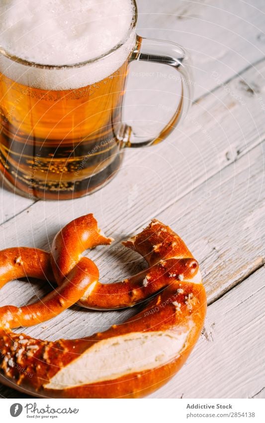 Bierglas und Brezel Bar Getränk Coolness trinken Schaum Lebensmittel Glas gold Becher Oktoberfest rustikal Salz Snack Tisch durstig altehrwürdig Holz