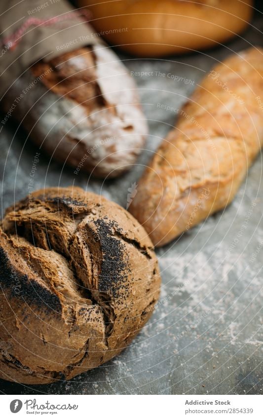 Rustikaler Brotlaib auf dunklem Hintergrund backen Bäckerei Frühstück Kohlenhydrat dunkel Mehl Lebensmittel selbstgebacken gebastelt rustikal Samen Typen Weizen