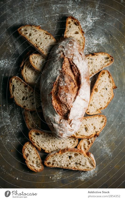 Rustikaler Brotlaib auf dunklem Hintergrund backen Bäckerei Frühstück Kohlenhydrat dunkel Mehl Lebensmittel selbstgebacken gebastelt rustikal Samen Typen Weizen