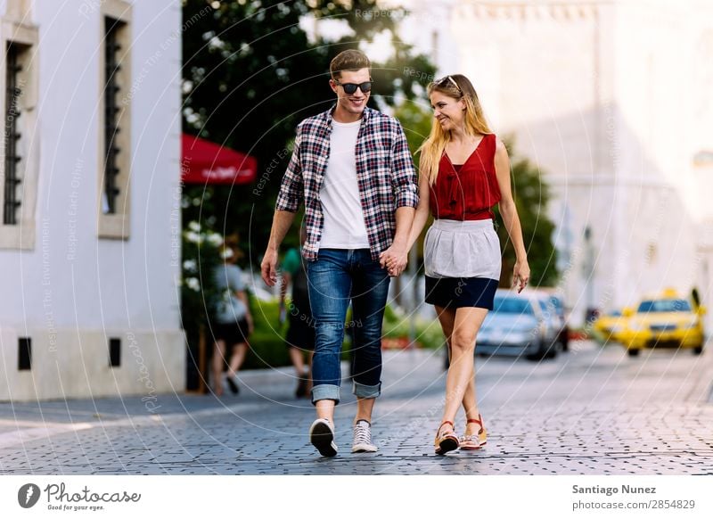 Romantisches junges Paar beim Spaziergang durch die Stadt. laufen Partnerschaft Liebe Jugendliche Glück lachen Lächeln Mensch Sommer Straße Großstadt Europa