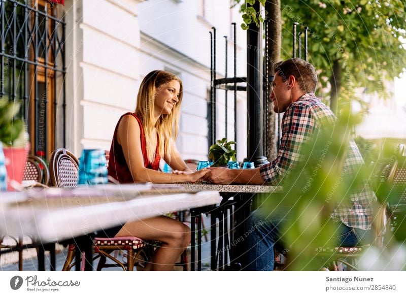 Junges Paar, das Spaß in der Stadt hat. sitzen Partnerschaft Liebe Jugendliche Halt Hand Blick Glück lachen Restaurant Terrasse Lächeln Mensch Liebespaar