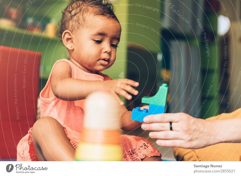 Frohes Baby beim Spielen mit Spielzeugblöcken. Kinderbetreuung Mulatte multiethnisch Kindergarten Porträt Schule Kleinkind Mädchen klein Blöcke Glück Fürsorge