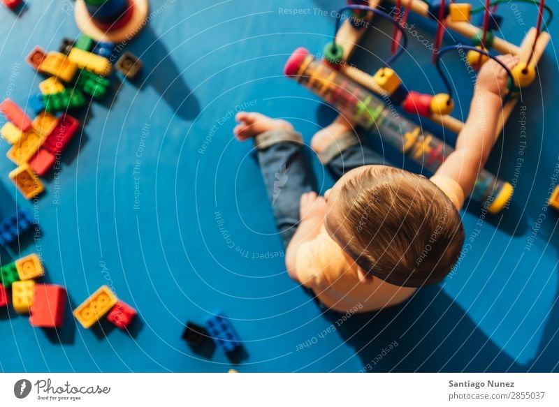 Frohes Baby beim Spielen mit Spielzeugblöcken. Kinderbetreuung Kindergarten Schule Kleinkind Junge klein LEGO Glück Fürsorge Etage niedlich Freude Vorschule