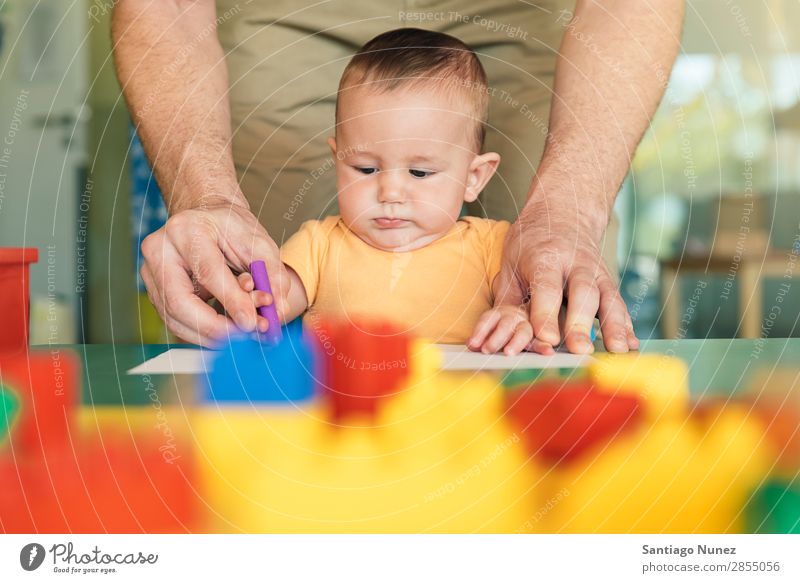 Kleinkind und Vater zeichnen auf einem Papier. Baby Spielen Kinderbetreuung Kindergarten Lehre Schule Papa Familie & Verwandtschaft lernen malen Spielzeug Farbe