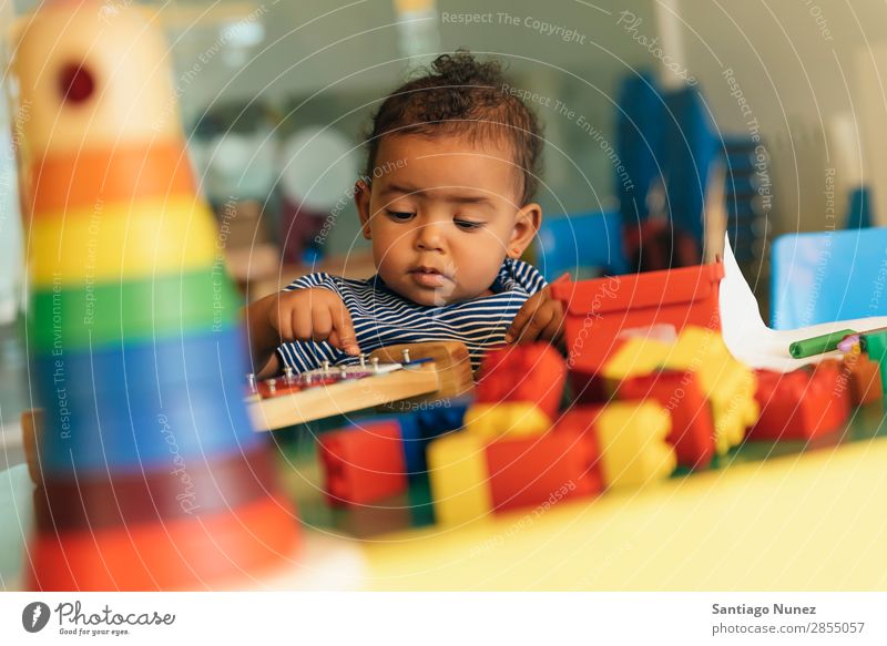 Frohes Baby beim Spielen mit Spielzeugblöcken. Kinderbetreuung Kindergarten Schule Kleinkind Mädchen klein Blöcke Glück Fürsorge niedlich Freude Vorschule