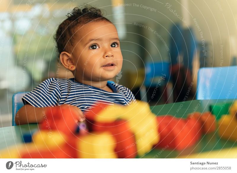 Frohes Baby beim Spielen mit Spielzeugblöcken. Kinderbetreuung Kindergarten Porträt Schule Kleinkind Mädchen klein Blöcke Glück Fürsorge niedlich Freude