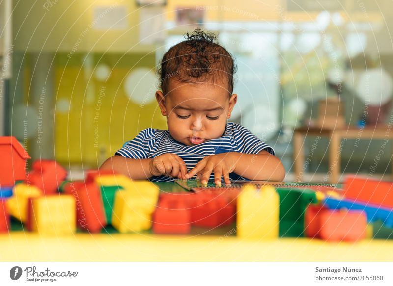 Frohes Baby beim Spielen mit Spielzeugblöcken. Kinderbetreuung Kindergarten Schule Kleinkind Mädchen klein Blöcke Glück Fürsorge niedlich Freude Vorschule