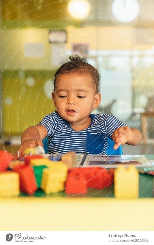 Frohes Baby beim Spielen mit Spielzeugblöcken. Kinderbetreuung Kindergarten Schule Kleinkind Mädchen klein Blöcke Glück Fürsorge niedlich Freude Vorschule