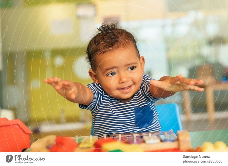 Frohes Baby beim Spielen mit Spielzeugblöcken. Kinderbetreuung Kindergarten Porträt Schule Kleinkind Mädchen klein Blöcke Glück Fürsorge niedlich Freude