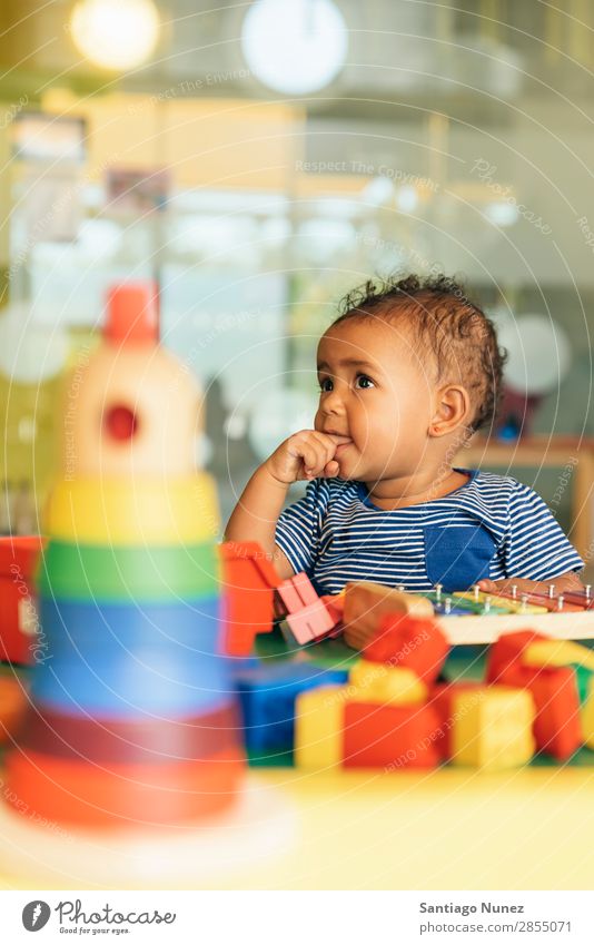 Frohes Baby beim Spielen mit Spielzeugblöcken. Kinderbetreuung Kindergarten Schule Kleinkind Mädchen klein Blöcke Glück Fürsorge niedlich Freude Vorschule