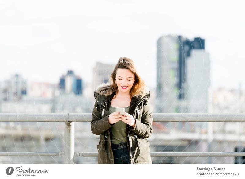 Glückliches Mädchen, das auf einem Smartphone schreibt. Telefon Mobile Frau Texten Mensch PDA SMS Hintergrundbild schön App Mitteilung benutzend Großstadt