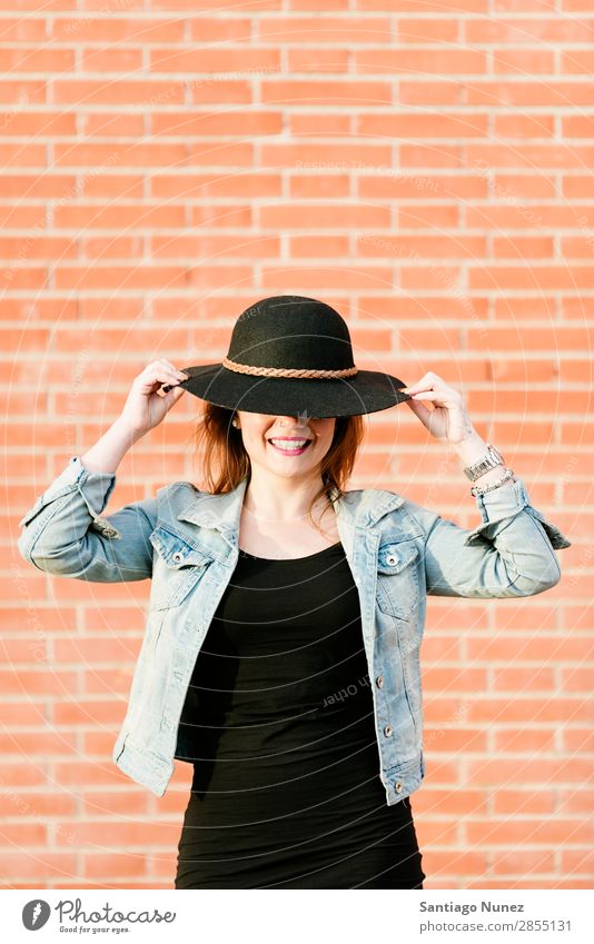 Blonder Hipster mit Strohhut auf orangem Ziegelgrund. Mode Wand Mädchen trendy Frau Jugendliche Schickimicki lässig Backstein Hintergrundbild Stil Porträt blond