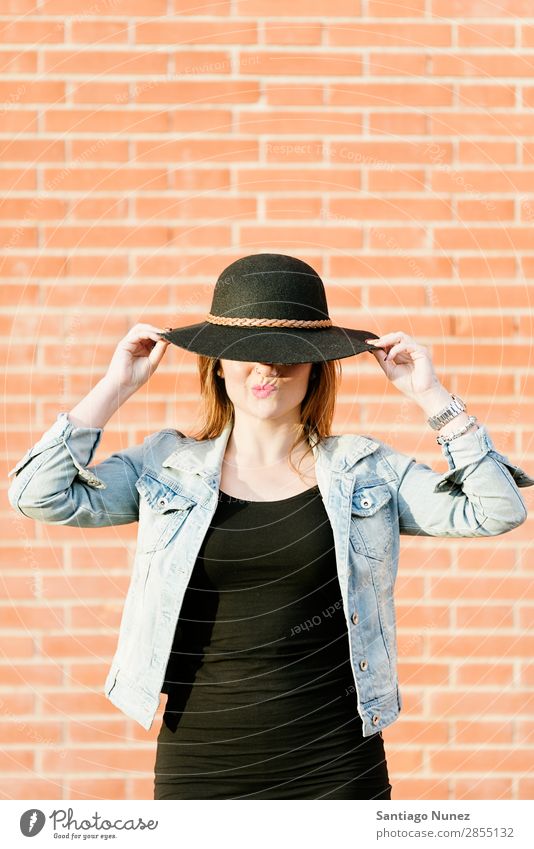 Blonder Hipster mit Strohhut auf orangem Ziegelgrund. Mode Wand Mädchen trendy Frau Jugendliche Schickimicki lässig Backstein Hintergrundbild Stil Porträt blond