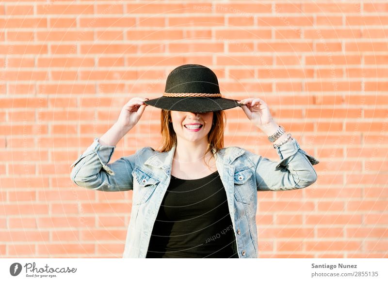 Blonder Hipster mit Strohhut auf orangem Ziegelgrund. Mode Wand Mädchen trendy Frau Jugendliche Schickimicki lässig Backstein Hintergrundbild Stil Porträt blond