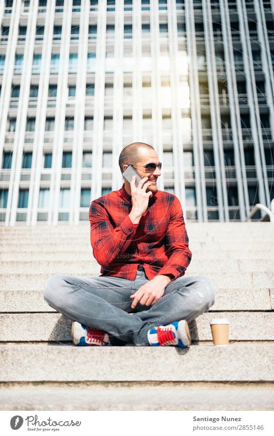 Junger Mann mit Handy in der Stadt. Mobile Telefon Schickimicki Lifestyle stehen Großstadt Gebäude Solarzelle PDA Mensch gutaussehend Stil Straße Kaffee