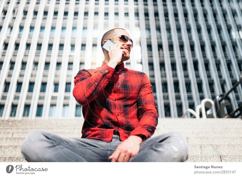 Junger Mann mit Handy in der Stadt. Mobile Telefon Schickimicki Lifestyle stehen Großstadt Gebäude Solarzelle PDA Mensch gutaussehend Stil Straße