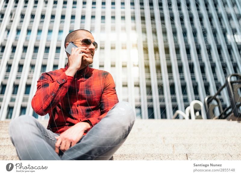 Junger Mann mit Handy in der Stadt. Mobile Telefon Schickimicki Lifestyle stehen Großstadt Gebäude Solarzelle PDA Mensch gutaussehend Stil Straße