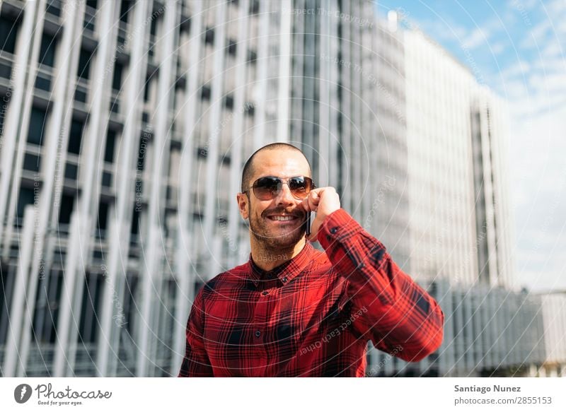 Junger Mann mit Handy in der Stadt. Mobile Telefon Schickimicki Lifestyle stehen Großstadt Gebäude Solarzelle PDA Mensch gutaussehend Stil Straße